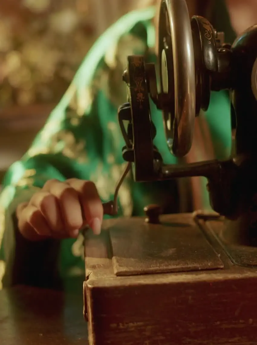 Vintage sewing machine during a demonstration, illustrative stock film still, not a photograph of Olga